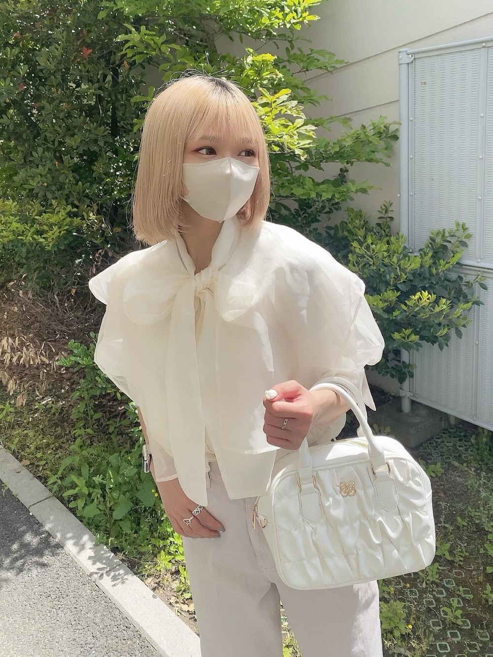 ホワイト系のボストンバッグ、ホワイト系のシャツ/ブラウス、ピンク系のデニムパンツを着用したレディースの春コーディネートの5枚目の写真