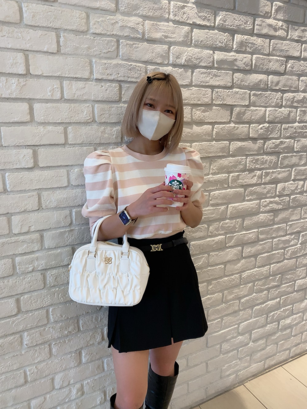 ピンク系のTシャツ/カットソー、ブラック系のスカート、ホワイト系のボストンバッグを着用したレディースの春コーディネートの2枚目の写真