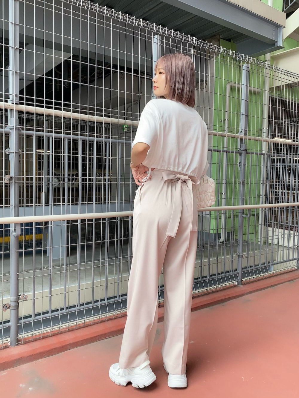 ホワイト系のTシャツ/カットソー、ピンク系のタンクトップ、ピンク系のスラックスを着用したレディースの夏コーディネートの4枚目の写真