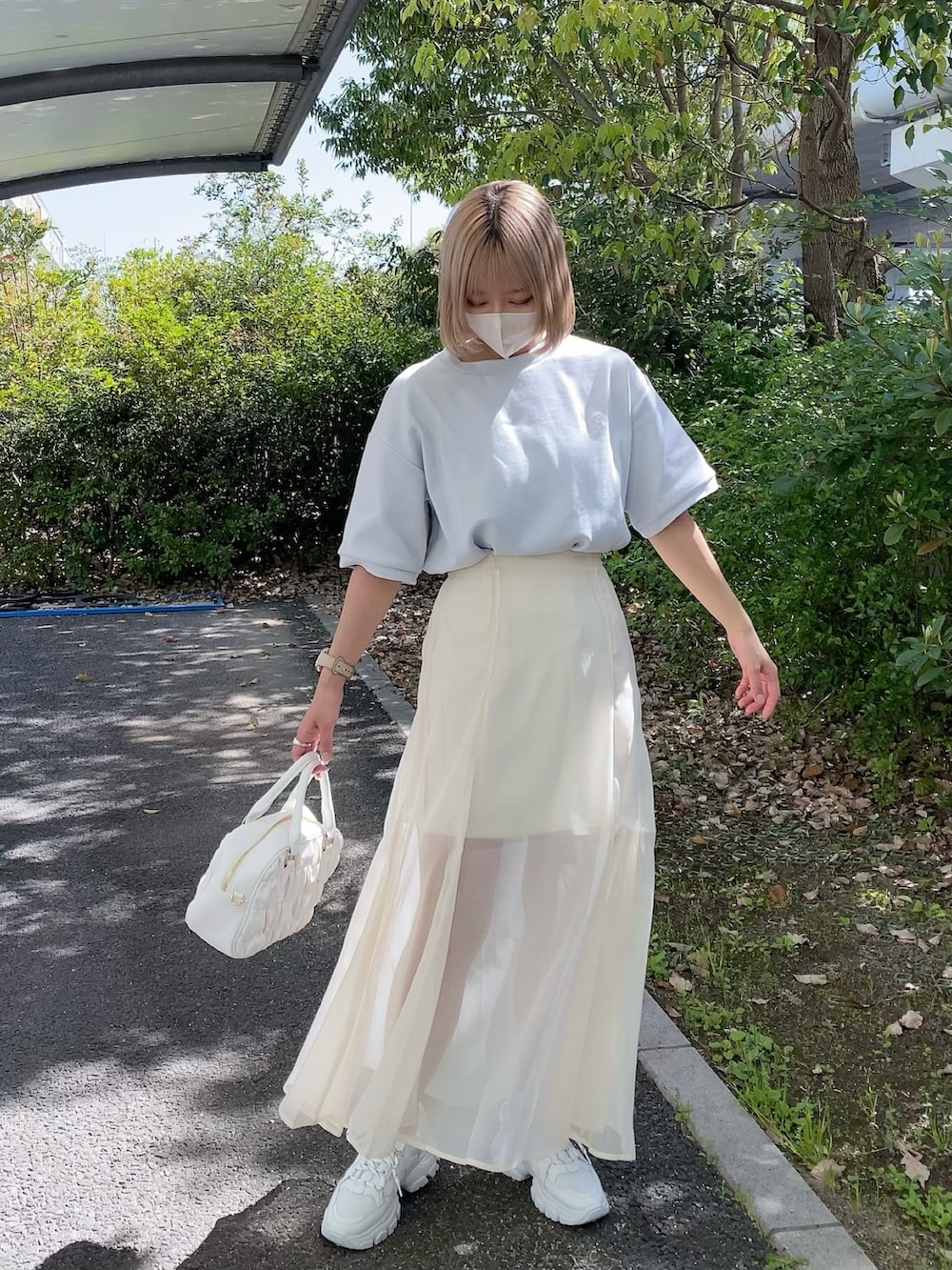 ホワイト系のボストンバッグ、ブルー系のTシャツ/カットソー、ホワイト系のスニーカーを着用したレディースの春コーディネートの2枚目の写真