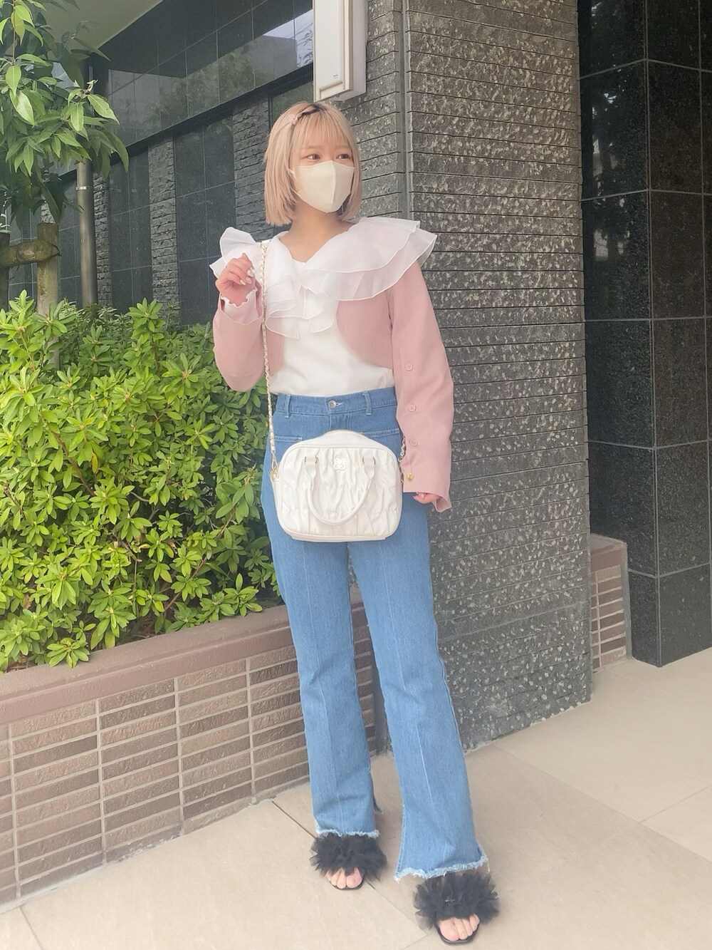 ブルー系のデニムパンツ、ホワイト系のボストンバッグ、ホワイト系のTシャツ/カットソーを着用したレディースの春コーディネートの2枚目の写真