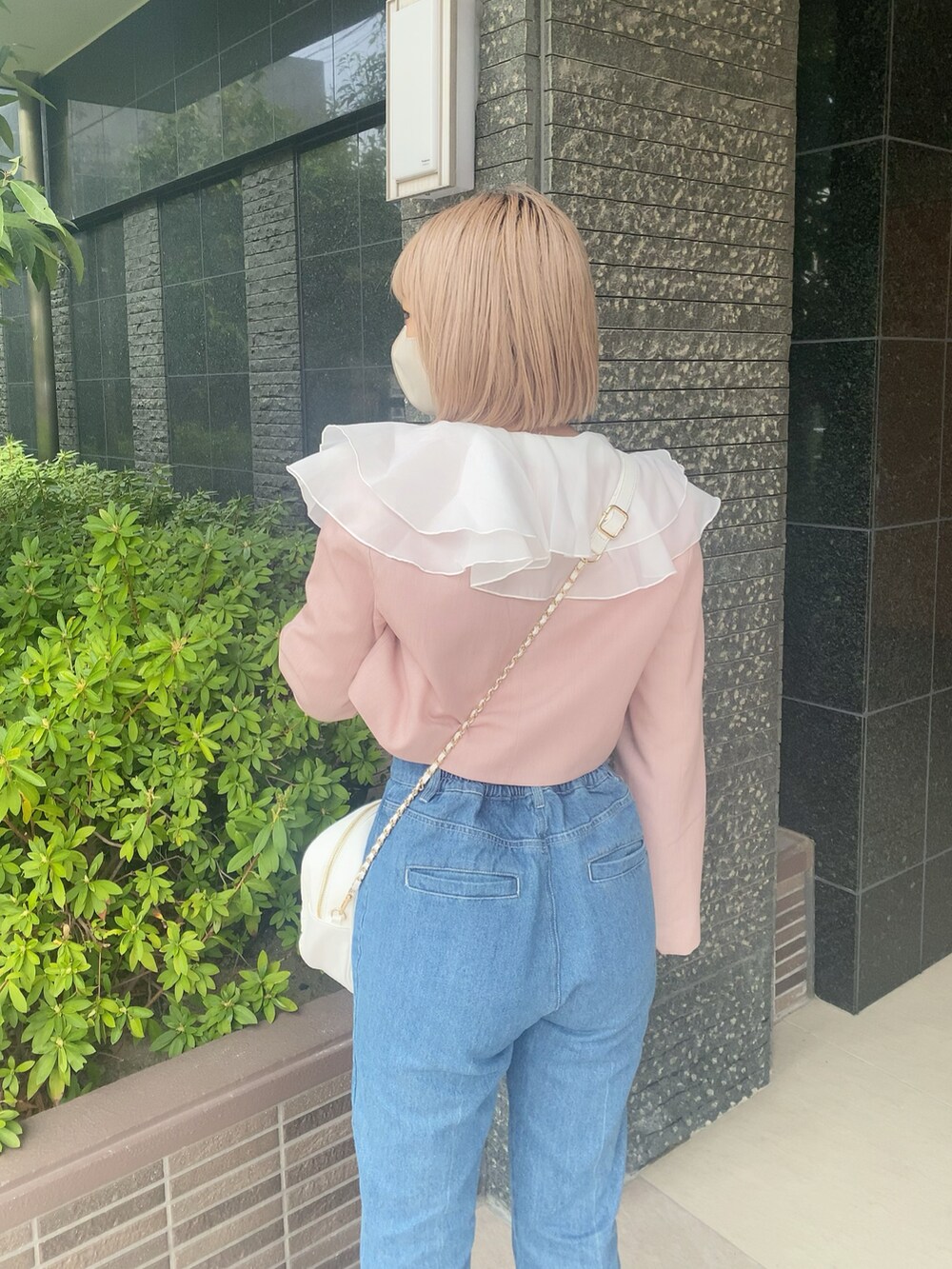 ブルー系のデニムパンツ、ホワイト系のボストンバッグ、ホワイト系のTシャツ/カットソーを着用したレディースの春コーディネートの5枚目の写真