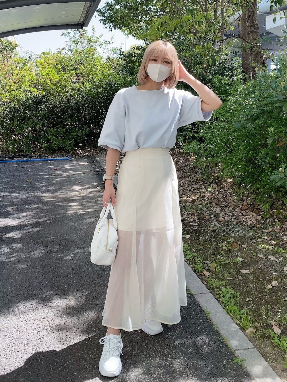 ホワイト系のボストンバッグ、ブルー系のTシャツ/カットソー、ホワイト系のスニーカーを着用したレディースの春コーディネートの3枚目の写真