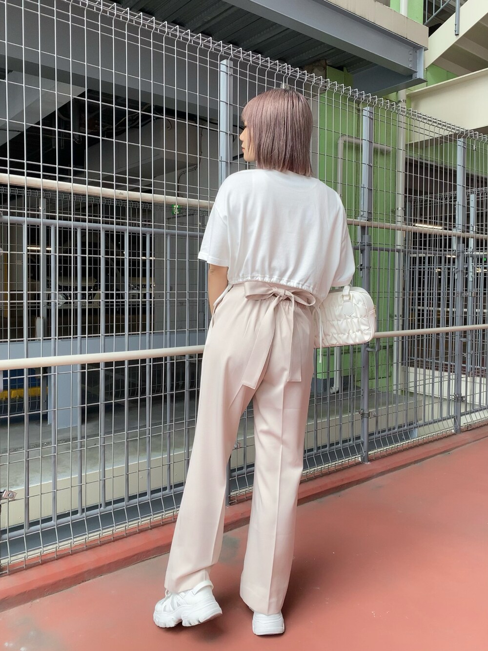 ホワイト系のTシャツ/カットソー、ピンク系のタンクトップ、ピンク系のスラックスを着用したレディースの夏コーディネートの2枚目の写真