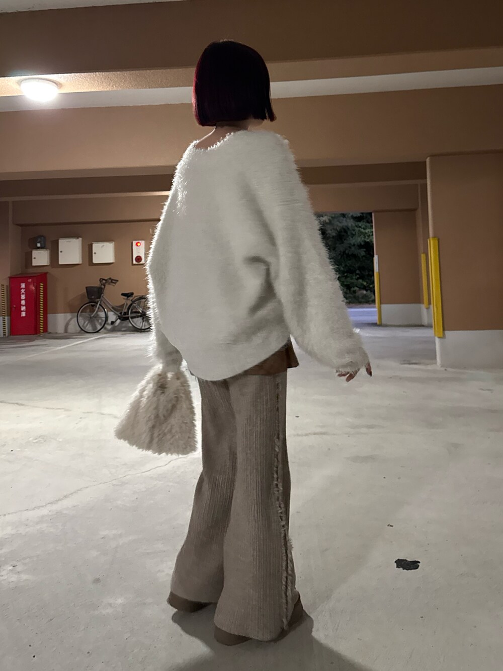 ホワイト系のニット/セーター、ブラウン系のスカート、ホワイト系のショルダーバッグを着用したレディースの冬コーディネートの3枚目の写真