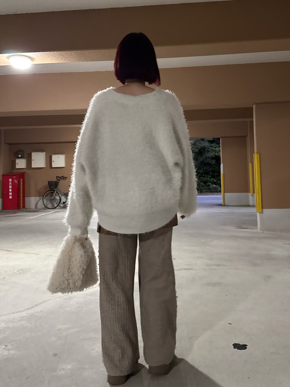 ホワイト系のニット/セーター、ブラウン系のスカート、ホワイト系のショルダーバッグを着用したレディースの冬コーディネートの2枚目の写真