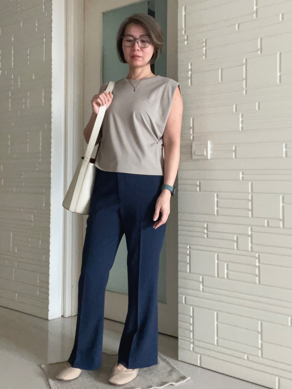 ブルー系のスラックス、ベージュ系のショルダーバッグ、ベージュ系のジャージを着用したレディースの秋コーディネートの2枚目の写真