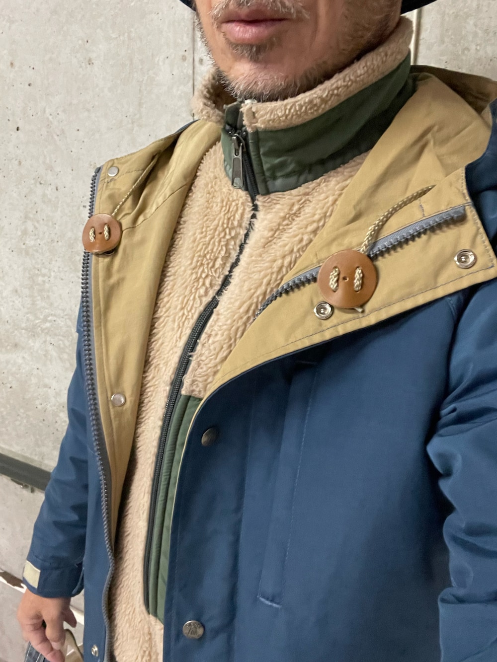 ベージュ系のその他アウター、ブラウン系のサンダル、ブルー系のマウンテンパーカーを着用したメンズの冬コーディネートの2枚目の写真