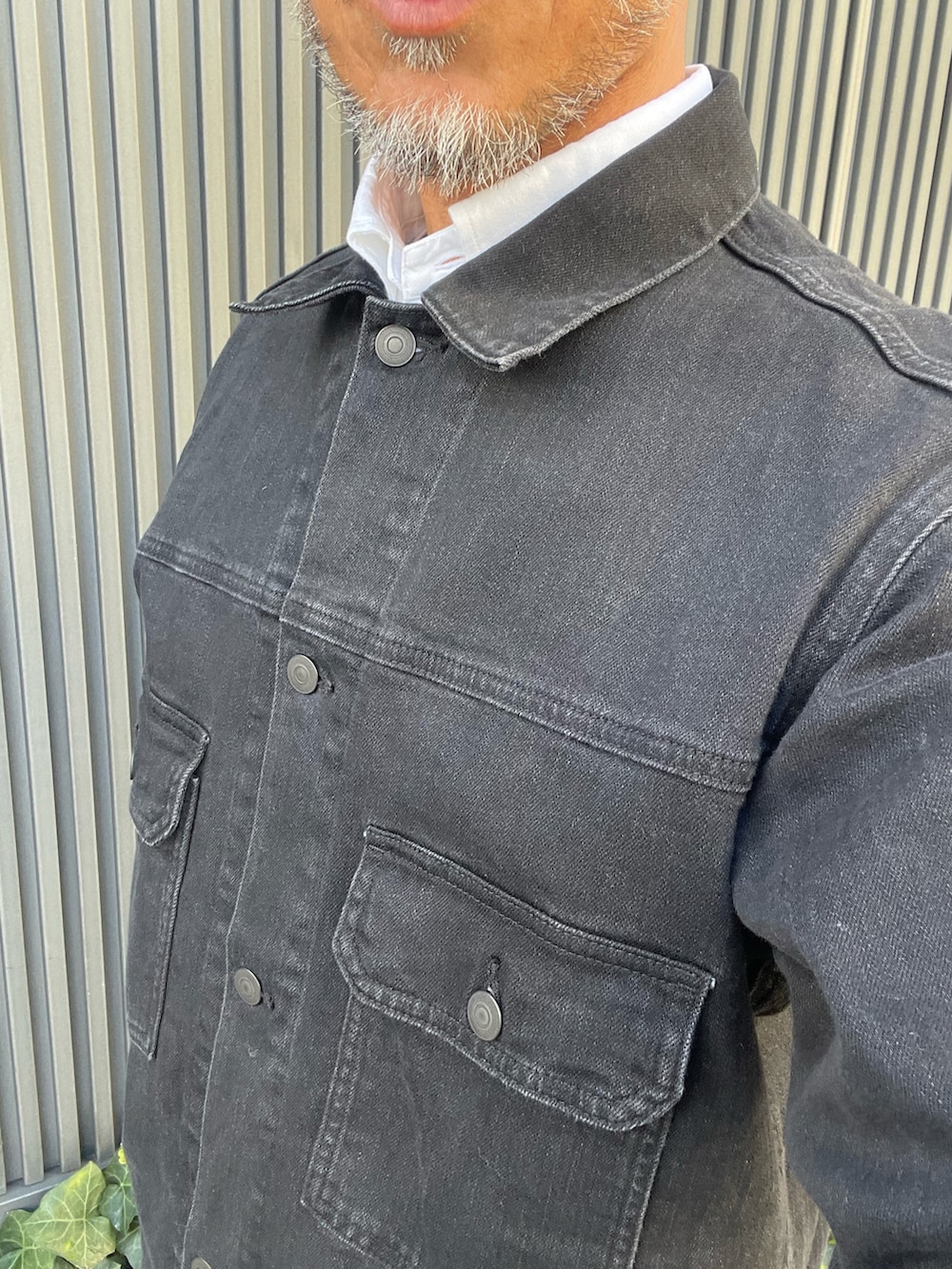 ブラック系のデニムジャケットを着用したメンズの秋コーディネートの2枚目の写真