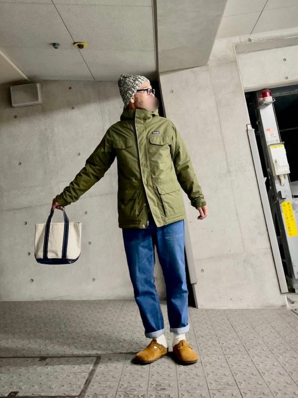 グリーン系のマウンテンパーカー、ブラウン系のサンダル、ホワイト系のソックス/靴下を着用したメンズの冬コーディネートの3枚目の写真