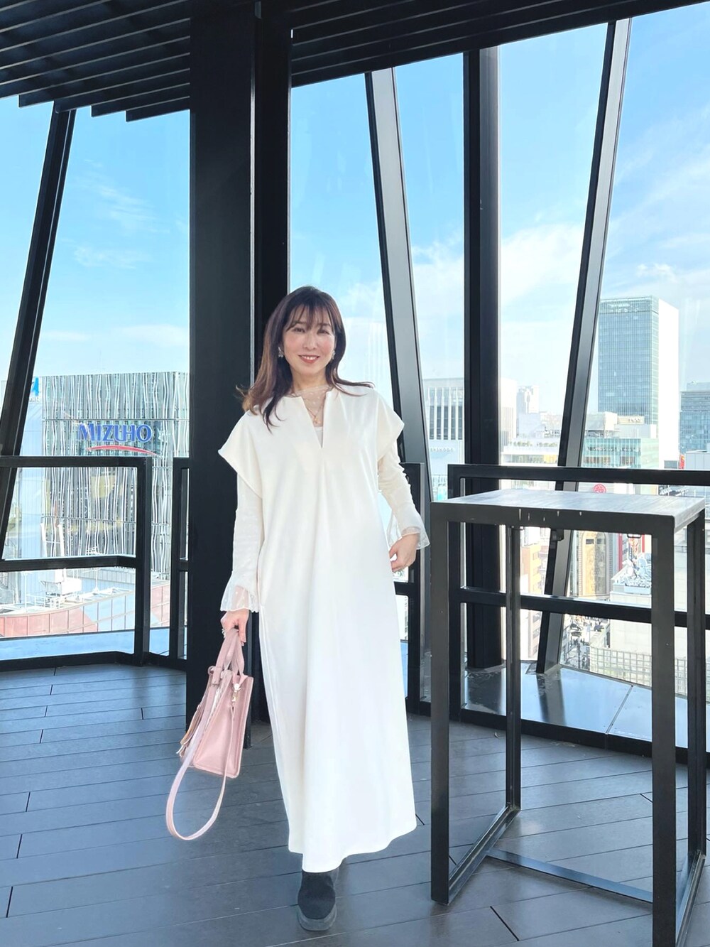 ホワイト系のワンピース、ピンク系のハンドバッグを着用したレディースの春コーディネートの2枚目の写真