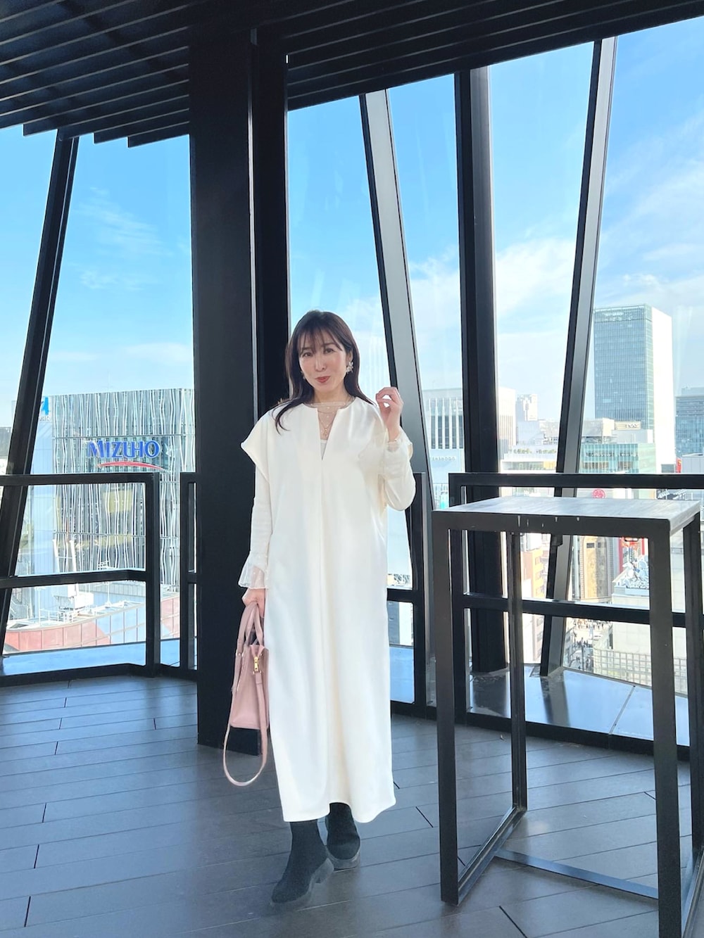 ホワイト系のワンピース、ピンク系のハンドバッグを着用したレディースの春コーディネートの3枚目の写真