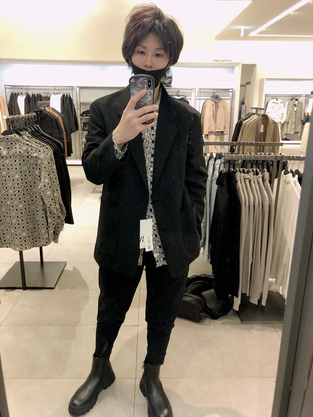 ブラック系のテーラードジャケット、ブラック系のスラックス、ブラック系のブーツを着用したメンズの秋コーディネートの4枚目の写真