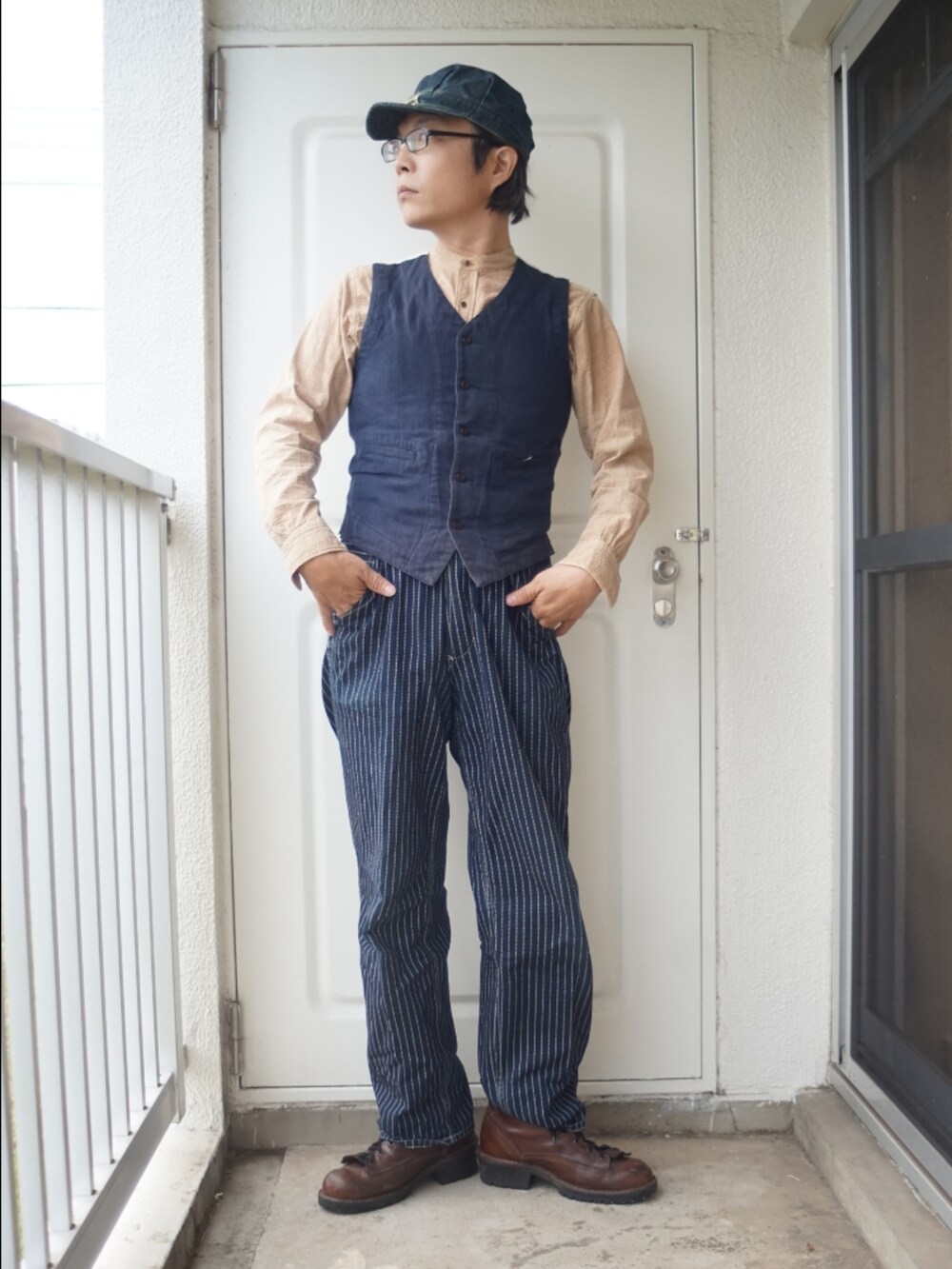 ブルー系のデニムパンツ、ブラウン系のブーツ、ベージュ系のシャツ/ブラウスを着用したメンズの冬コーディネートの2枚目の写真