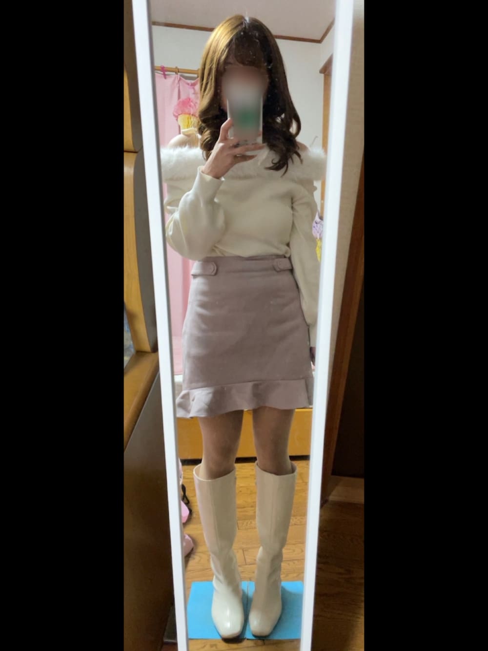 ピンク系のハンドバッグ、ピンク系のスカート、ホワイト系のニット/セーターを着用したレディースの冬コーディネートの2枚目の写真