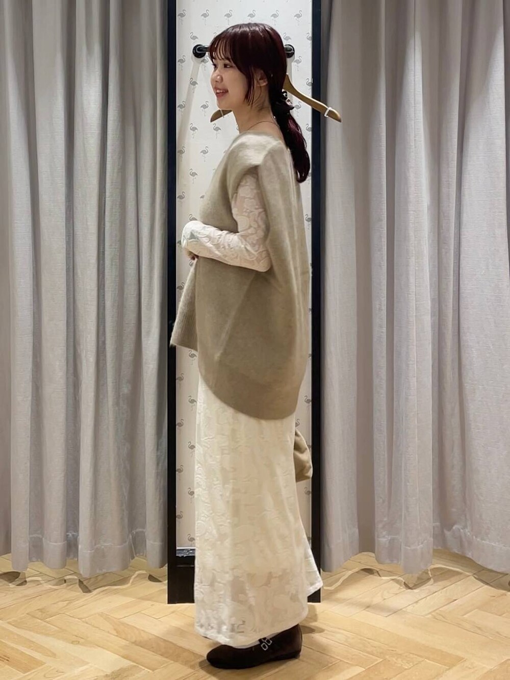 ベージュ系のベスト、ブラウン系のバレエシューズ、ベージュ系のショルダーバッグを着用したレディースの秋コーディネートの2枚目の写真