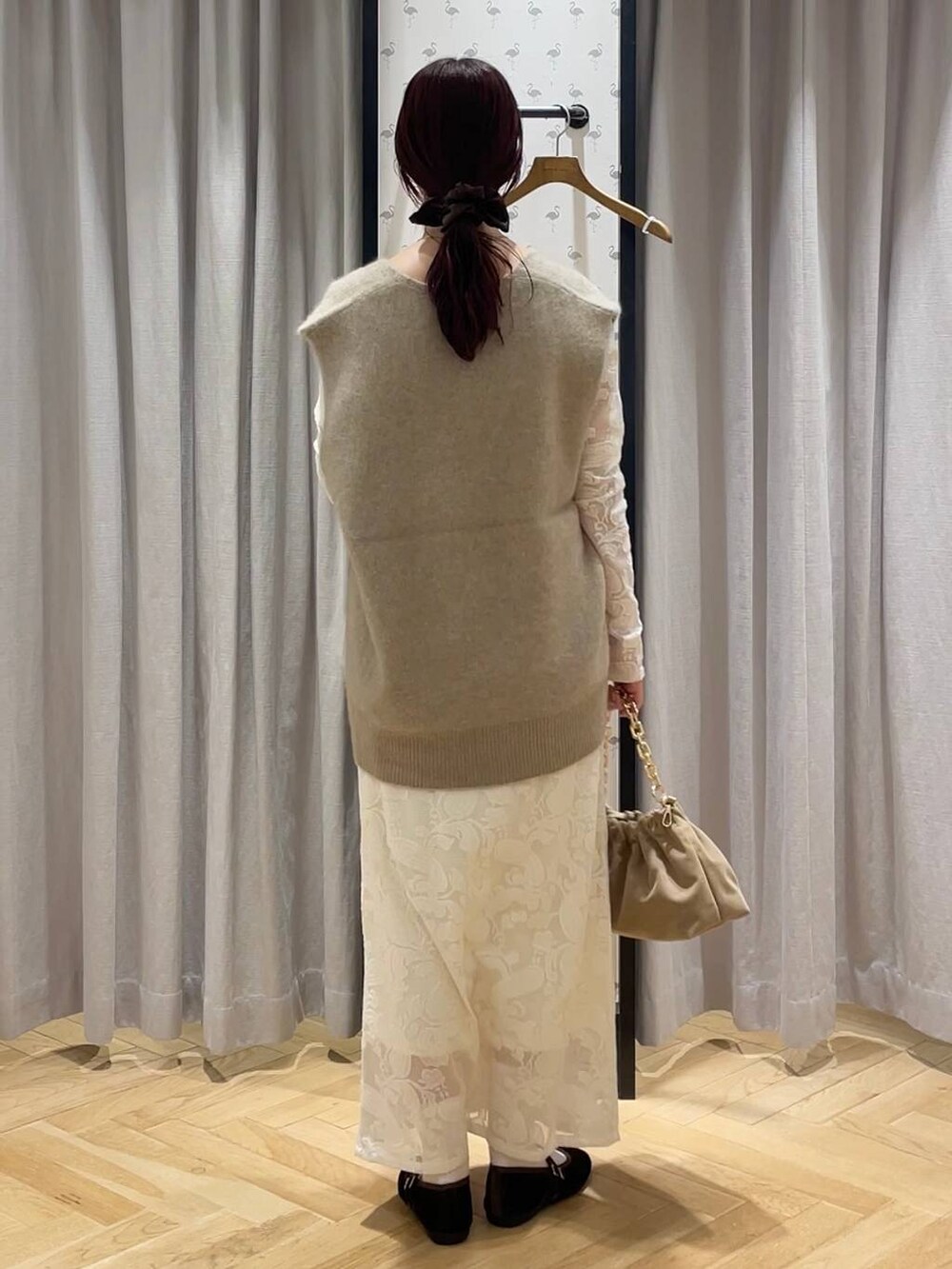 ベージュ系のベスト、ブラウン系のバレエシューズ、ベージュ系のショルダーバッグを着用したレディースの秋コーディネートの3枚目の写真