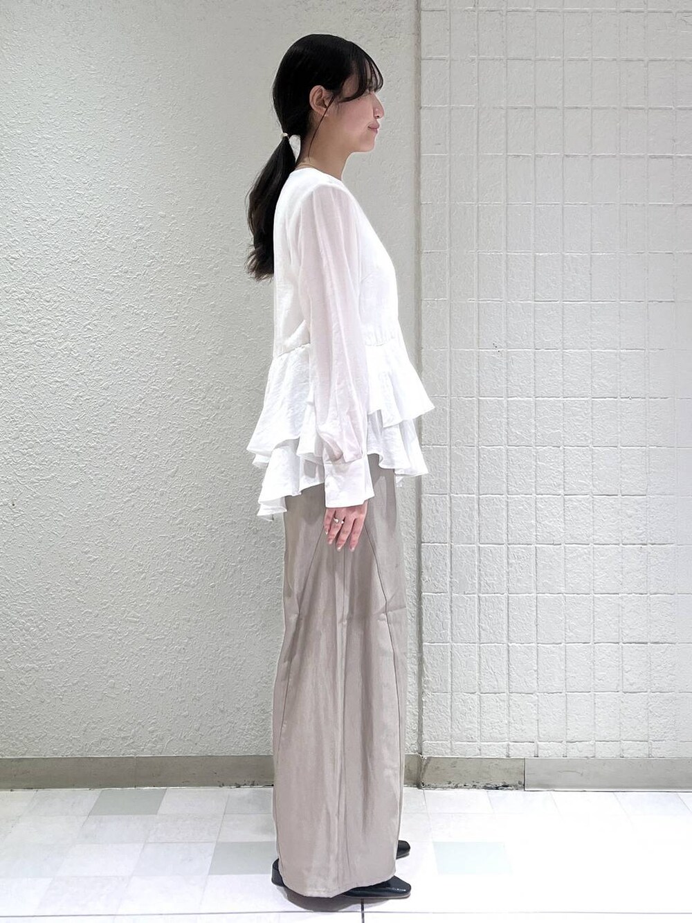 グレー系のその他パンツ、ブラック系のショルダーバッグ、ホワイト系のシャツ/ブラウスを着用したレディースの春コーディネートの2枚目の写真
