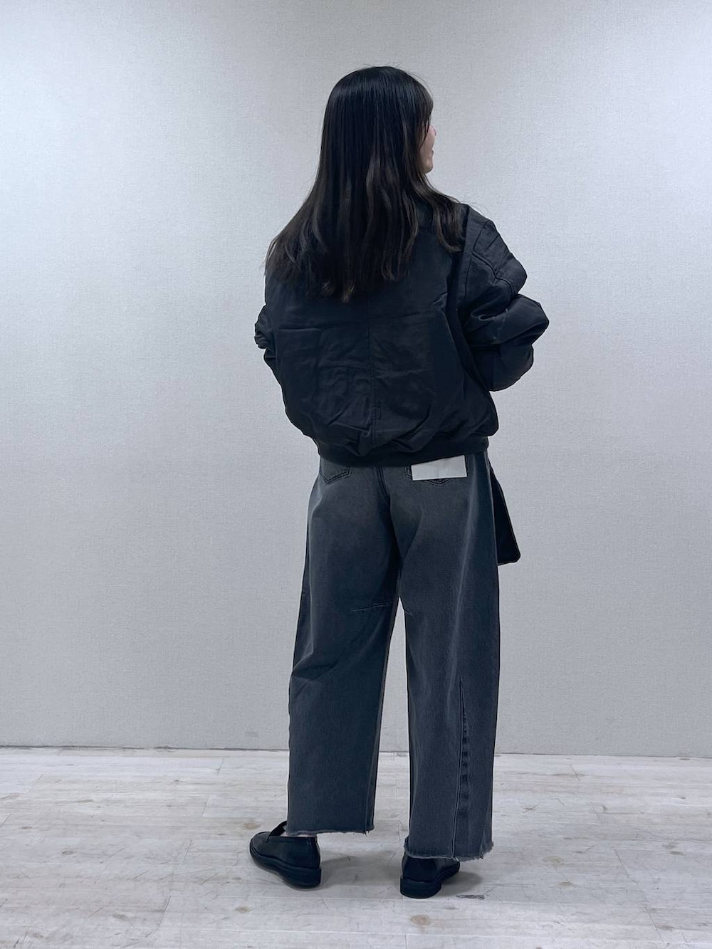 ブラック系のローファー、グレー系のMA-1、グレー系のデニムパンツを着用したレディースの春コーディネートの3枚目の写真