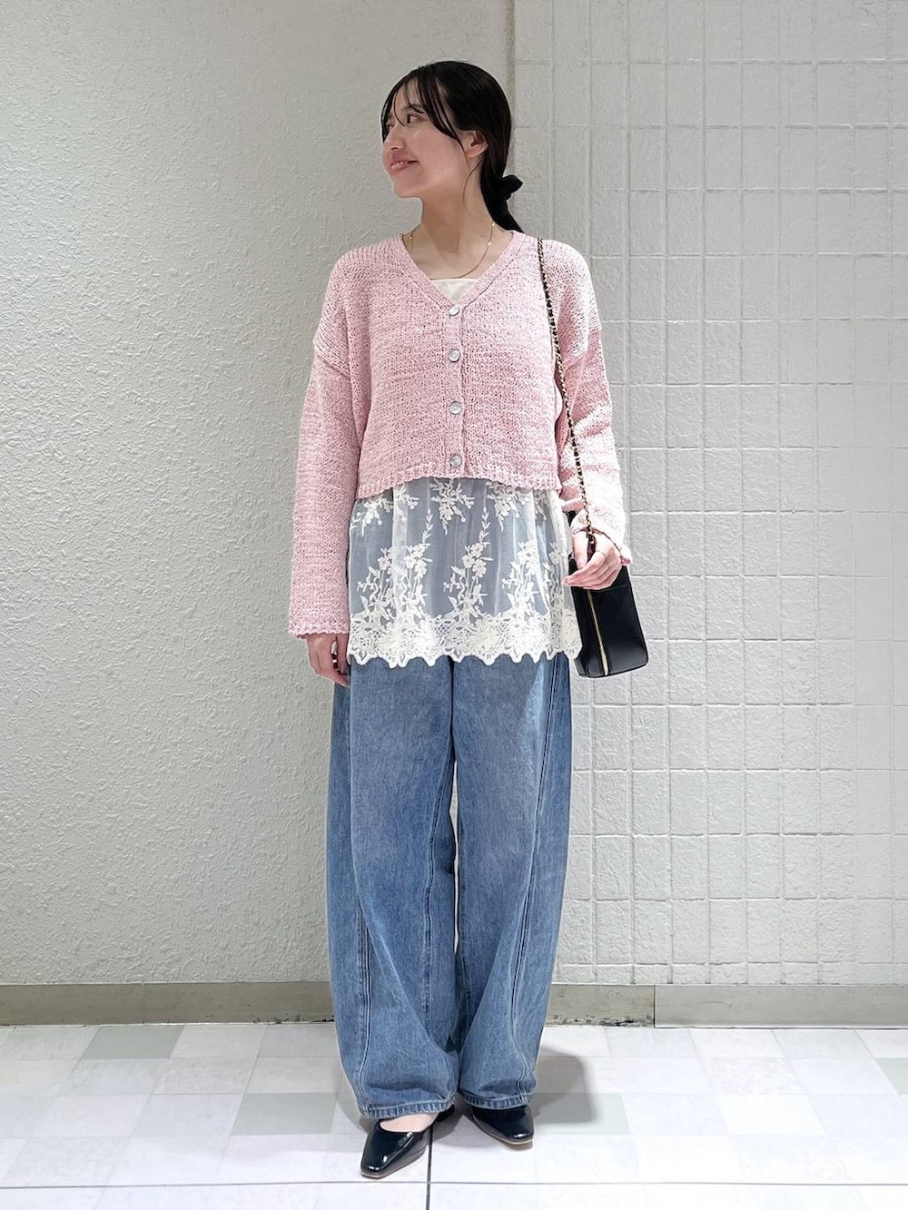 ブルー系のデニムパンツ、ベージュ系のブルゾン、ホワイト系のキャミソールを着用したレディースの春コーディネートの2枚目の写真