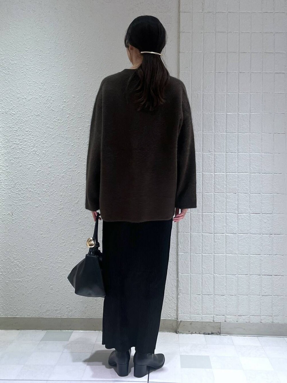 ブラウン系のカーディガン/ボレロ、ブラック系のブーツ、ブラック系のスカートを着用したレディースの秋コーディネートの3枚目の写真