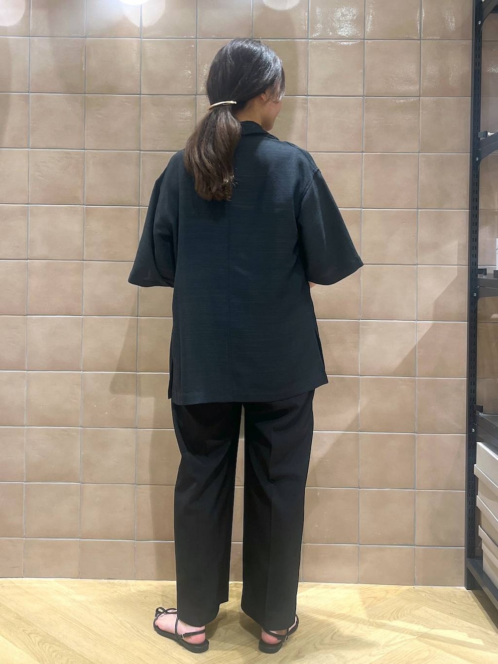 ブラック系のサロペット/オーバーオール、ブラック系のテーラードジャケット、ブラック系のサンダルを着用したレディースの春コーディネートの3枚目の写真