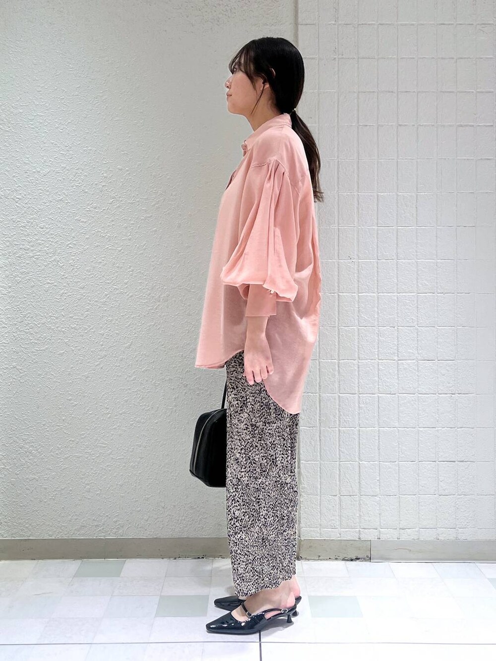 ピンク系のシャツ/ブラウス、ブラック系のボストンバッグ、ブラック系のパンプスを着用したレディースの春コーディネートの3枚目の写真