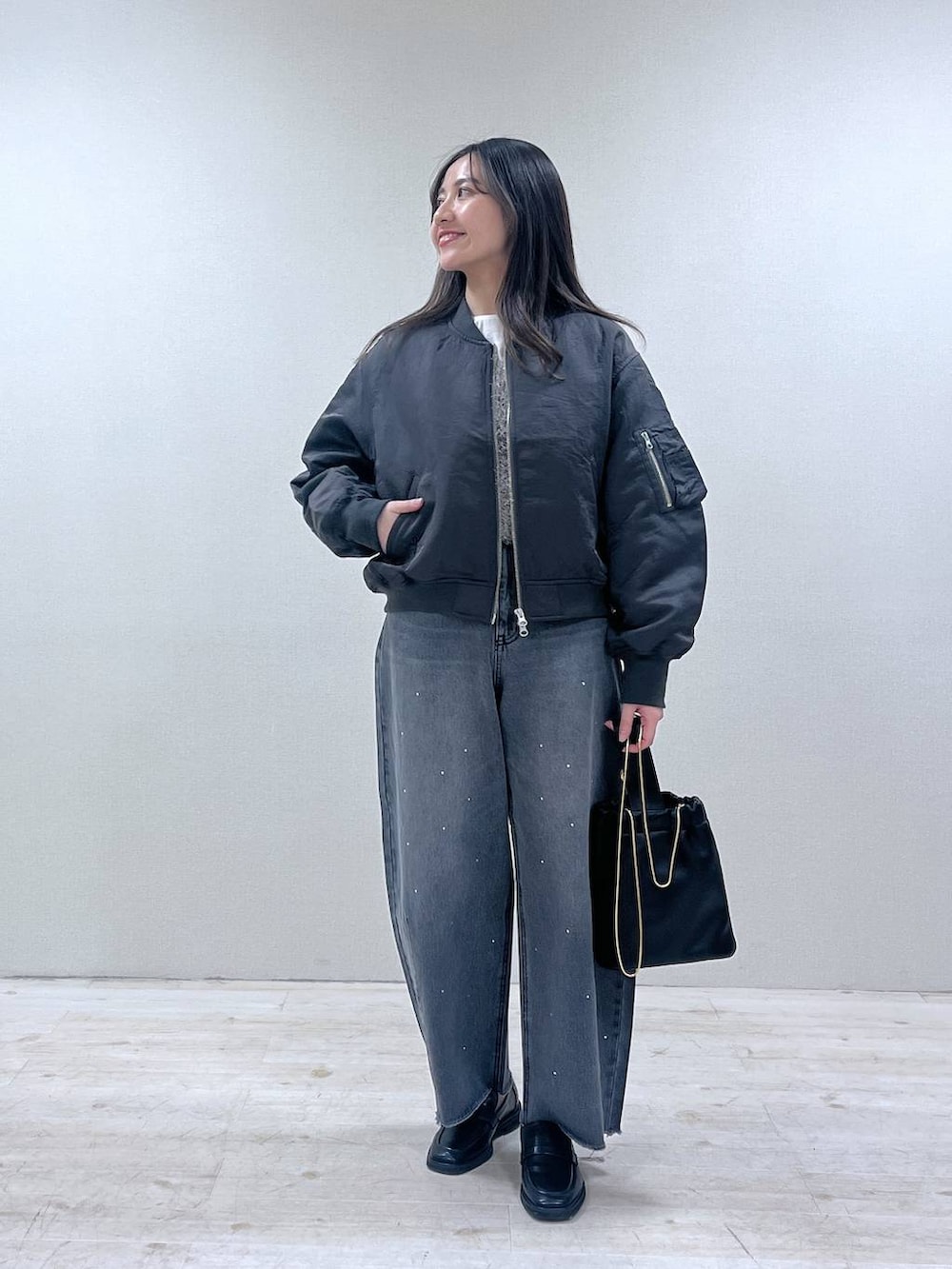 ブラック系のローファー、グレー系のMA-1、グレー系のデニムパンツを着用したレディースの春コーディネートの4枚目の写真