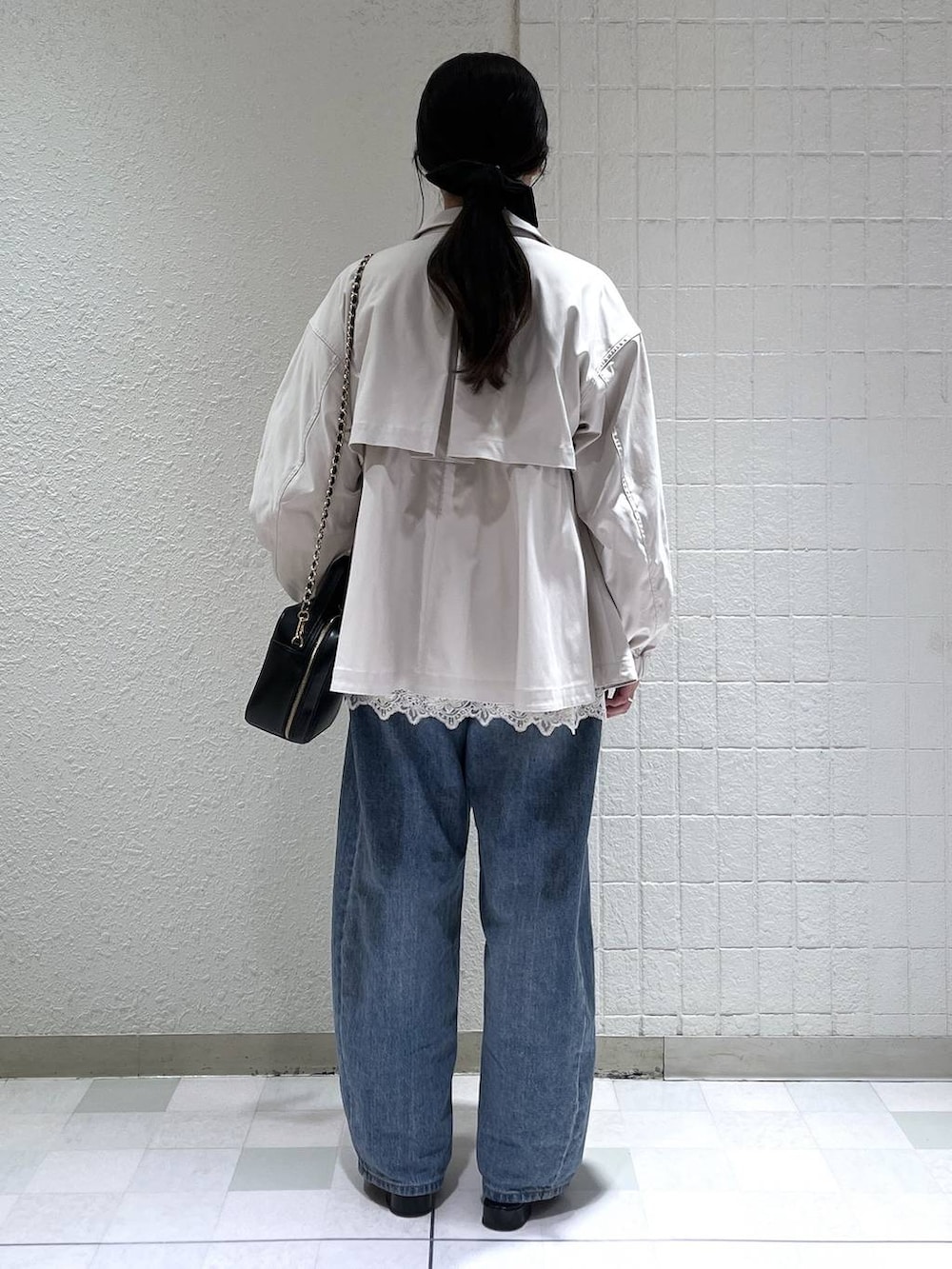 ブルー系のデニムパンツ、ベージュ系のブルゾン、ホワイト系のキャミソールを着用したレディースの春コーディネートの4枚目の写真