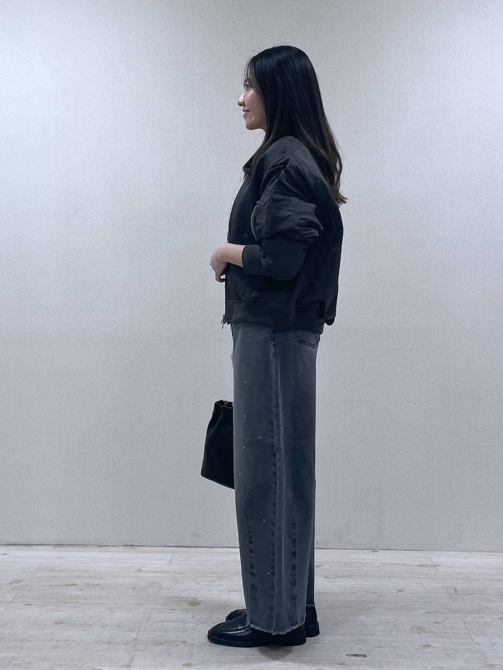 ブラック系のローファー、グレー系のMA-1、グレー系のデニムパンツを着用したレディースの春コーディネートの2枚目の写真