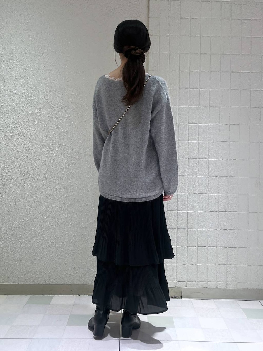 ブラック系のブーツ、ブラック系のスカート、グレー系のニット/セーターを着用したレディースの秋コーディネートの3枚目の写真
