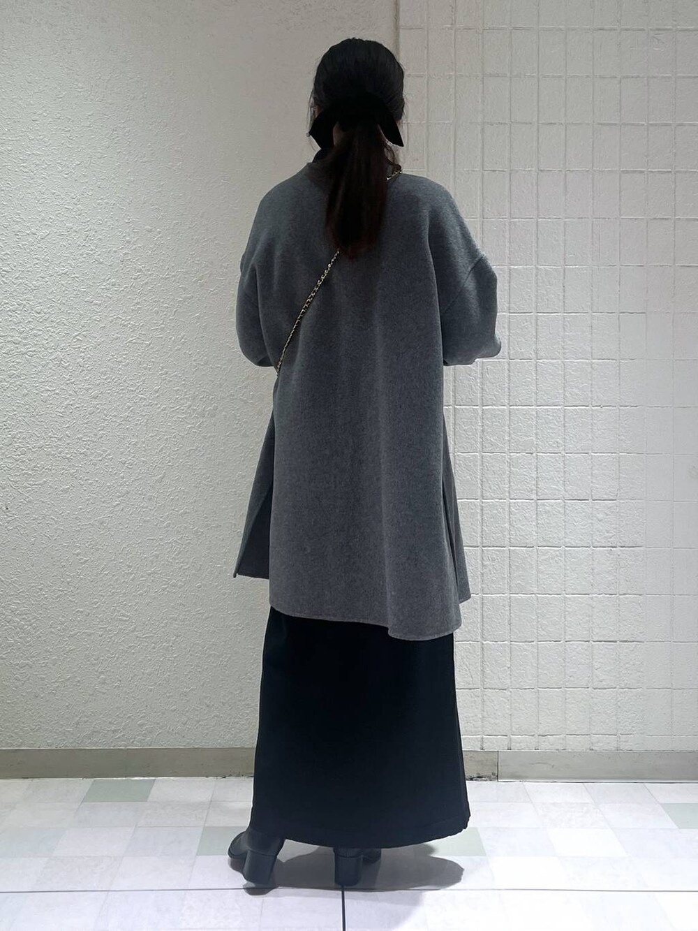 ブラック系のブーツ、グレー系のノーカラーコートを着用したレディースの秋コーディネートの3枚目の写真