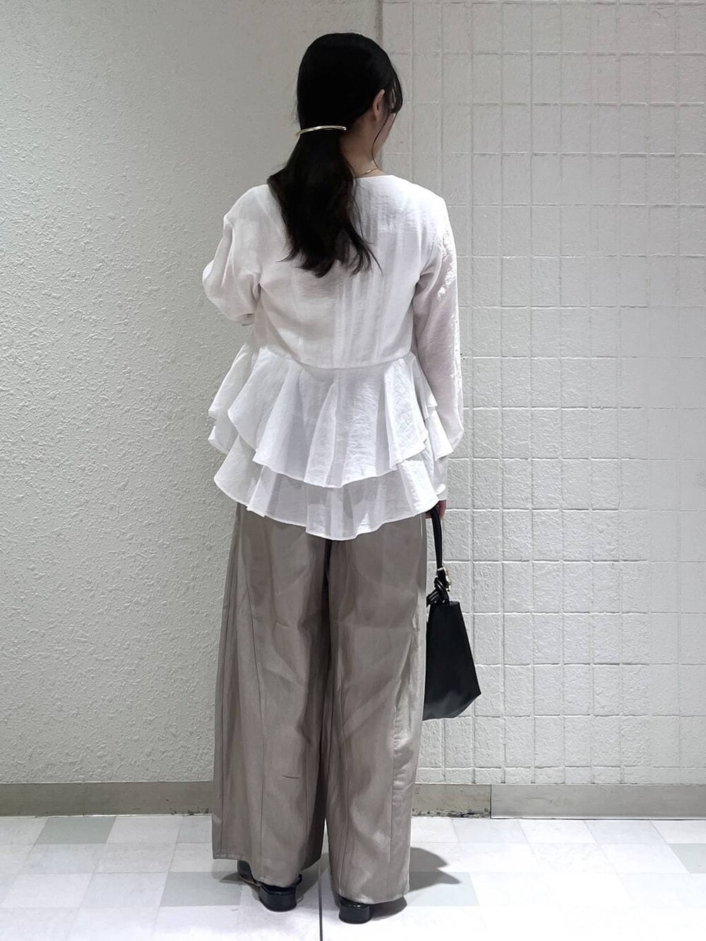 グレー系のその他パンツ、ブラック系のショルダーバッグ、ホワイト系のシャツ/ブラウスを着用したレディースの春コーディネートの3枚目の写真