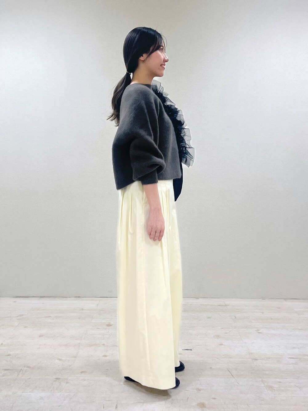 ブラウン系のニット/セーター、ブラック系のローファー、ブラック系のショルダーバッグを着用したレディースの春コーディネートの2枚目の写真