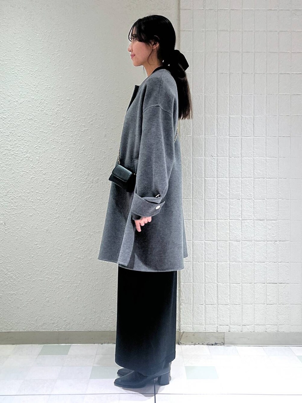 ブラック系のブーツ、グレー系のノーカラーコートを着用したレディースの秋コーディネートの2枚目の写真
