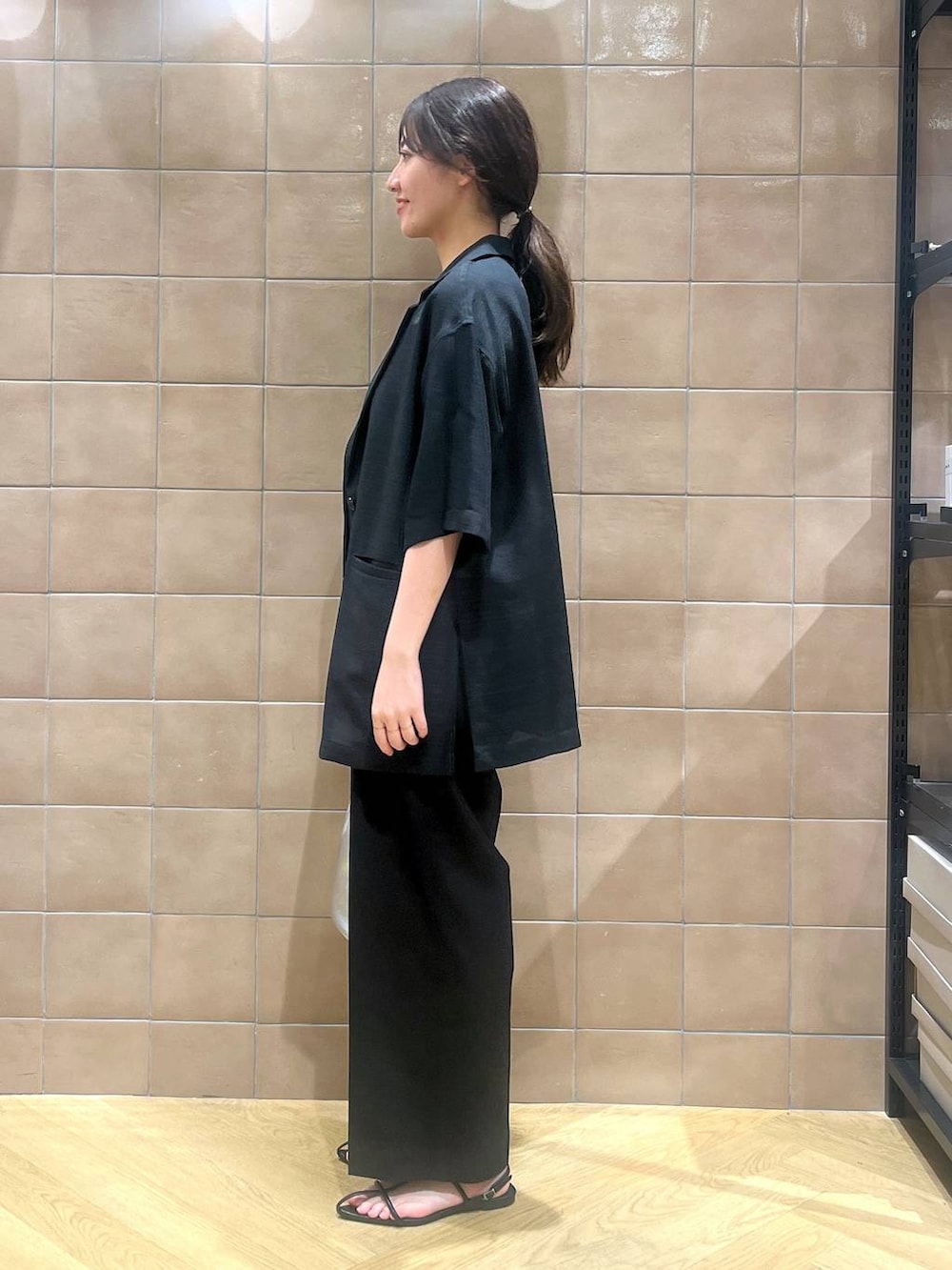 ブラック系のサロペット/オーバーオール、ブラック系のテーラードジャケット、ブラック系のサンダルを着用したレディースの春コーディネートの2枚目の写真