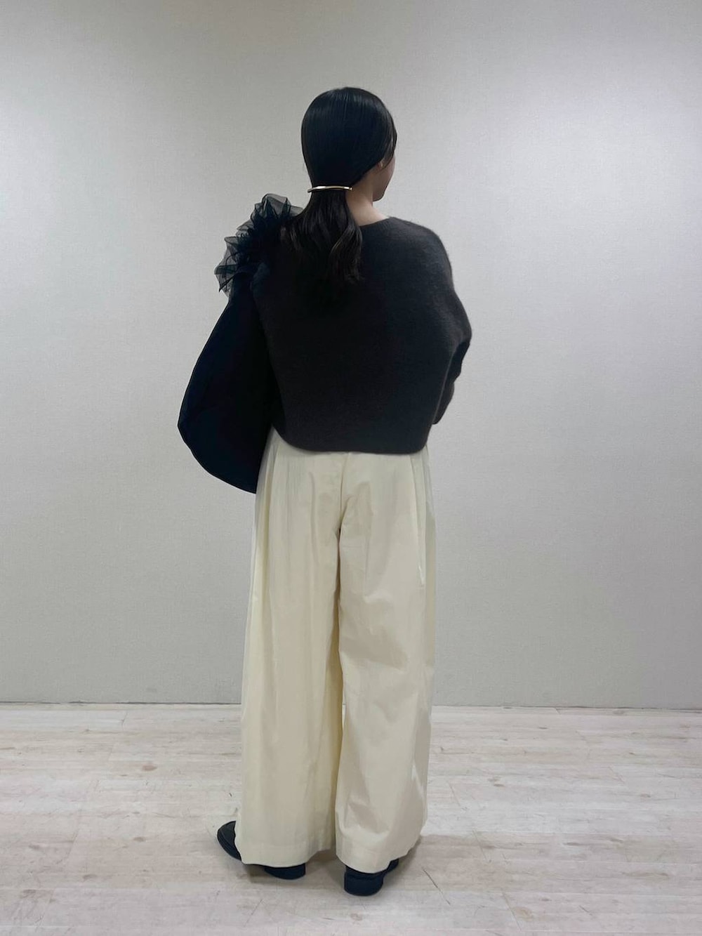 ブラウン系のニット/セーター、ブラック系のローファー、ブラック系のショルダーバッグを着用したレディースの春コーディネートの3枚目の写真