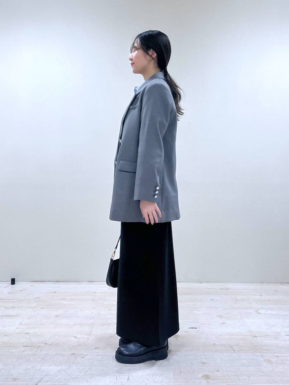 ブルー系のシャツ/ブラウス、ブラック系のショルダーバッグ、ブラック系のスカートを着用したレディースの冬コーディネートの2枚目の写真