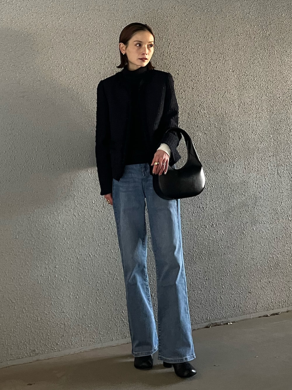 ブルー系のデニムパンツ、ブルー系のノーカラージャケット、ブラック系のショルダーバッグを着用したレディースの冬コーディネートの2枚目の写真