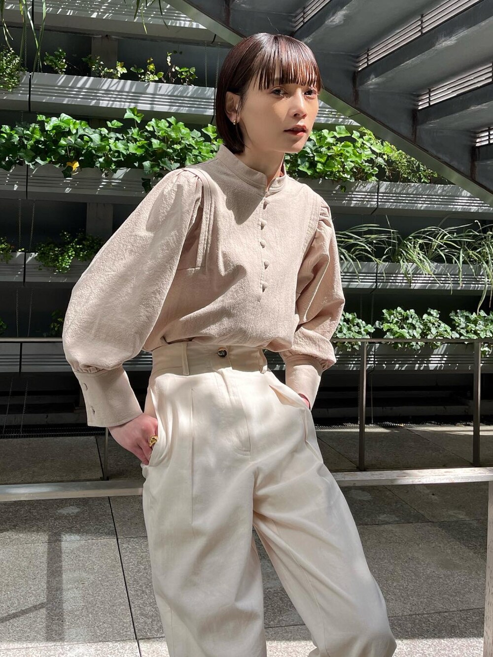 ホワイト系のその他パンツ、ベージュ系のシャツ/ブラウス、ブラウン系のパンプスを着用したレディースの春コーディネートの3枚目の写真