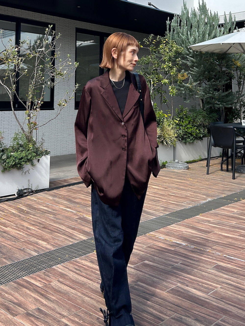 ブラウン系のシャツ/ブラウス、ブルー系のデニムパンツを着用したレディースの春コーディネートの2枚目の写真