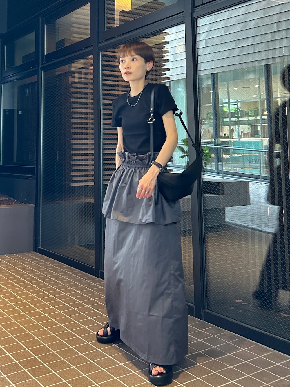 グレー系のスカートを着用したレディースの夏コーディネートの4枚目の写真