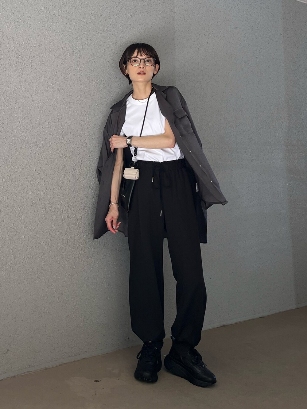 グレー系のシャツ/ブラウス、ブラック系のスニーカー、ホワイト系のTシャツ/カットソーを着用したレディースの夏コーディネートの2枚目の写真