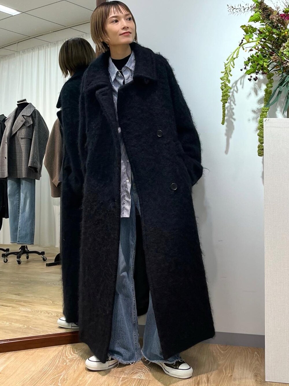 ブラック系のその他アウター、ブルー系のデニムパンツ、グリーン系のスニーカーを着用したレディースの秋コーディネートの2枚目の写真