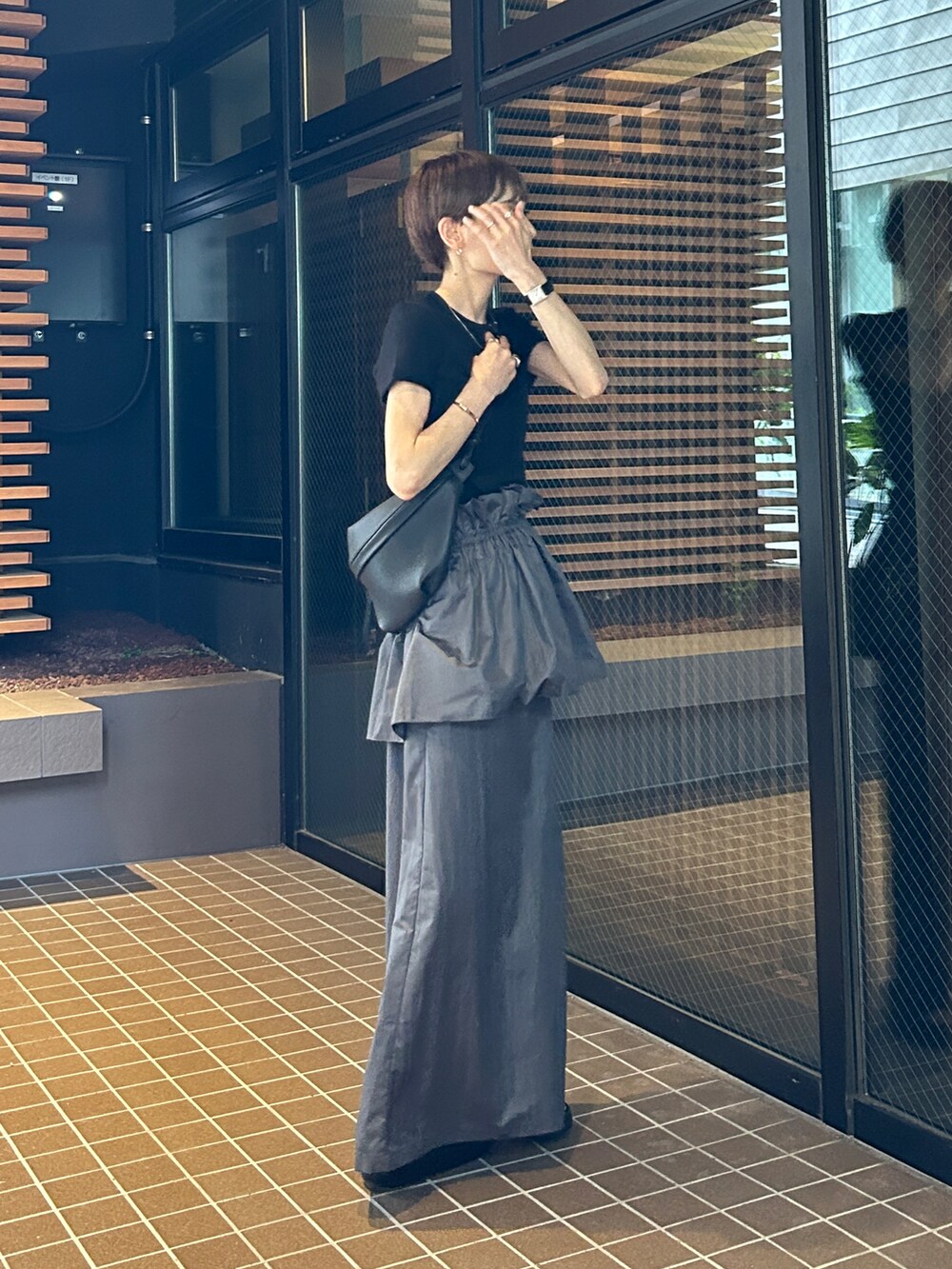 グレー系のスカートを着用したレディースの夏コーディネートの5枚目の写真