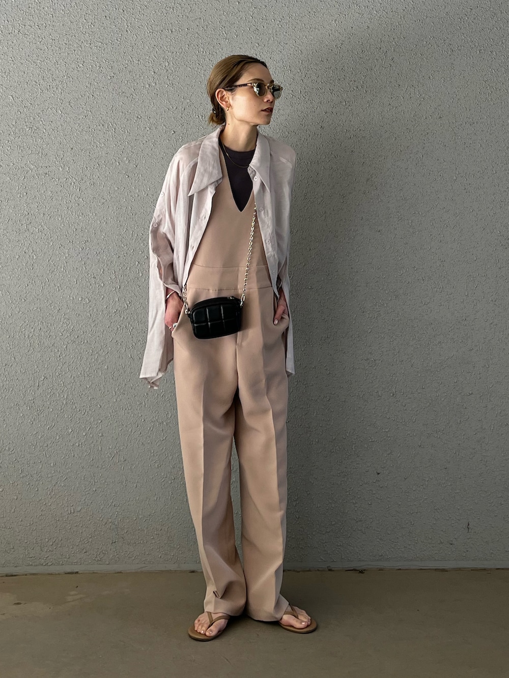 ベージュ系のビーチサンダル、ベージュ系のサロペット/オーバーオール、ブラック系のショルダーバッグを着用したレディースの春コーディネートの4枚目の写真