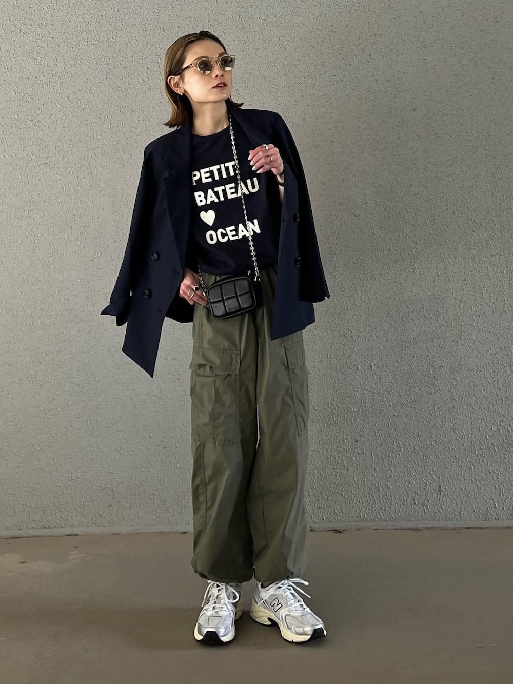 ブルー系のTシャツ/カットソー、ブラック系のショルダーバッグ、グリーン系のカーゴパンツを着用したレディースの春コーディネートの2枚目の写真