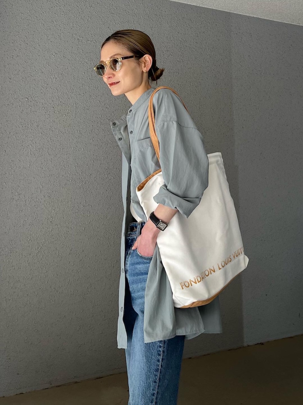 ブルー系のデニムパンツ、ベージュ系のビーチサンダル、ブルー系のラッシュガードを着用したレディースの春コーディネートの3枚目の写真