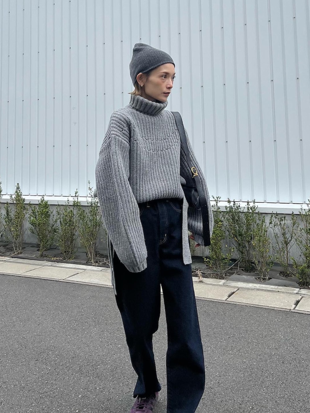 グレー系のニット/セーター、ブルー系のデニムパンツ、レッド系のスニーカーを着用したレディースの秋コーディネートの3枚目の写真