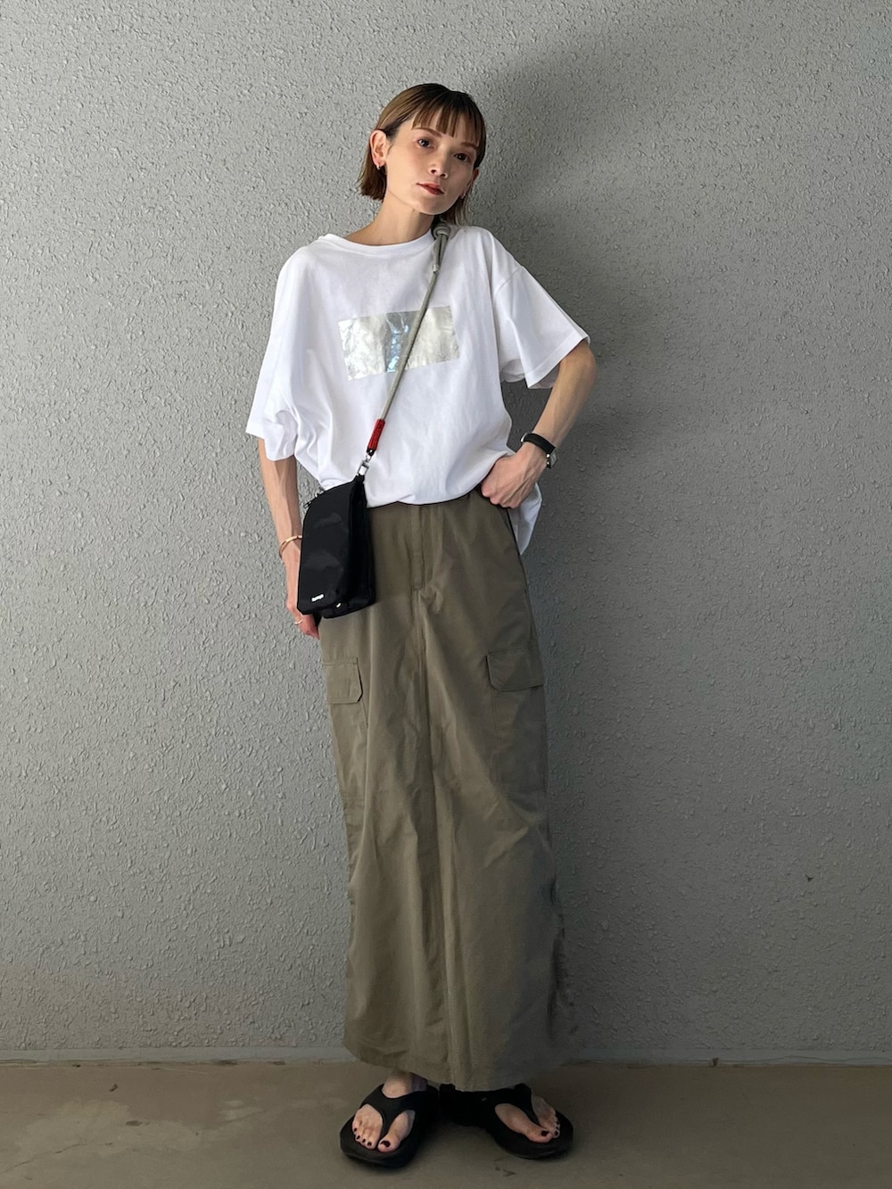 ホワイト系のTシャツ/カットソー、グリーン系のスカート、ブラック系のショルダーバッグを着用したレディースの秋コーディネートの2枚目の写真